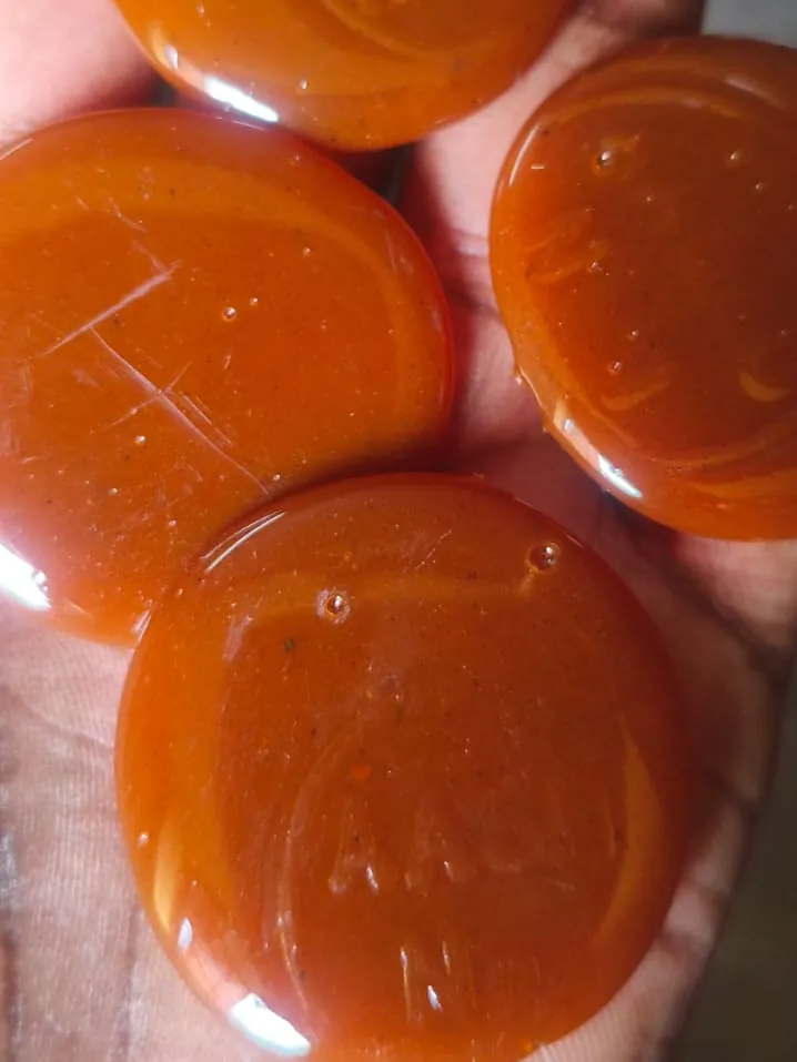Glossy orange button lac discs close up