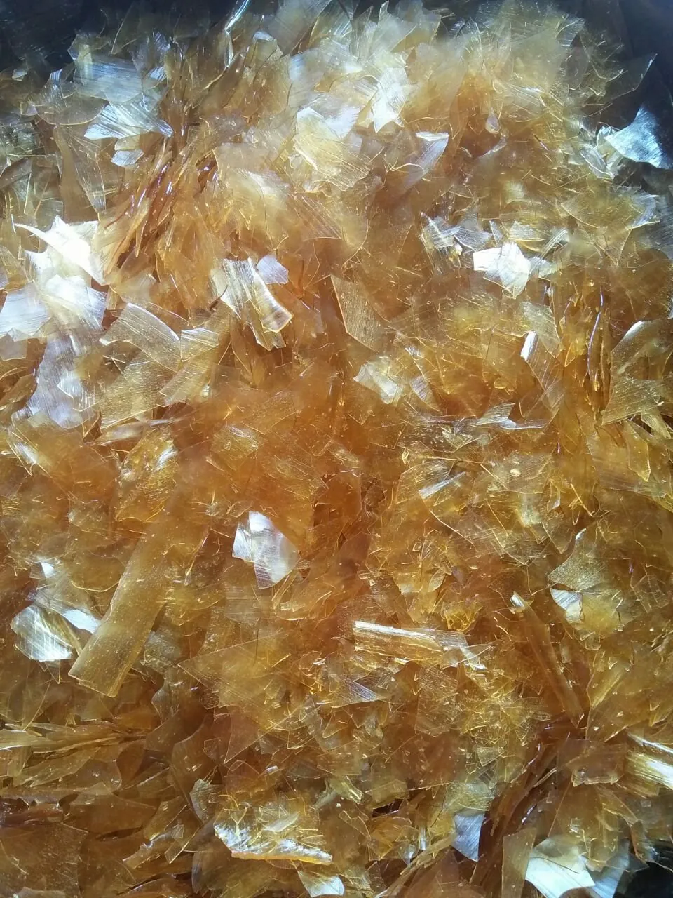 Amber dewaxed shellac flakes, close-up